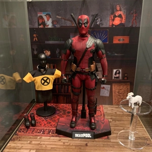 Deadpool action figure set with red suit, X-Men vest, unicorn model, and display base