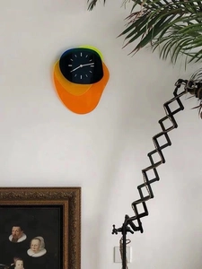 Close-up of modern multilayered acrylic wall clock with minimalist dial and vibrant shapes