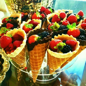 16-hole clear acrylic ice cream cone holder stand with fruit-filled waffle cones