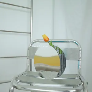 Vaso a specchio futuristico in PVC argento con un vivace accento di tulipano arancione