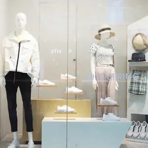 Minimalist beech wood display rack showcasing white sneakers and apparel in a store