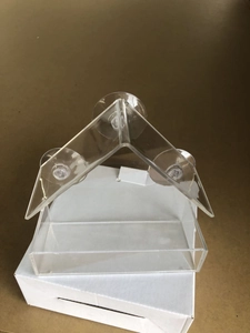 Close-up of clear acrylic house-shaped bird feeder with three strong suction cups for window