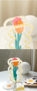 Close-up of acrylic checkerboard vase with daisy patterns and 3D tulip decorations