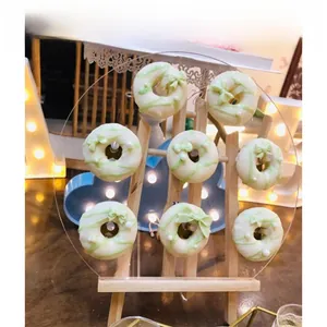 Detail of 8-piece cream white and green donut charms displayed on an acrylic stand