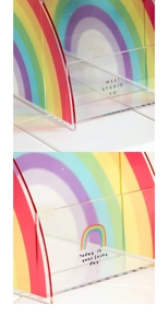 Detail of rainbow acrylic desk organizer with lucky day slogan on a white surface