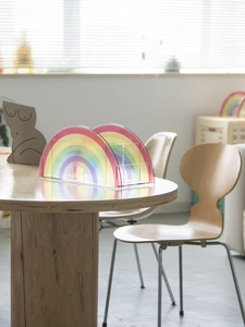 Macro detail of translucent rainbow acrylic desktop organizer on a wooden surface