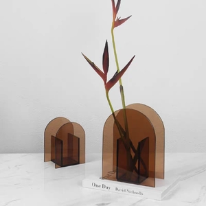 Detail of amber acrylic arched vases showing modern geometric design on marble surface
