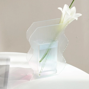 Detailed close-up of wavy acrylic vase featuring vertical ribbed texture and clear finish