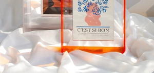 Close-up of vibrant acrylic photo frames with elegant art cards on soft silk fabric