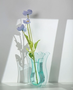 Dettaglio del vaso a onde in acrilico blu con papavero artificiale e luce naturale