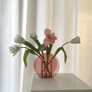 Makroaufnahme einer rosa runden Acryl-Vase mit minimalistischem Blumensteckplatz