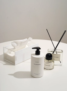 Detail view of transparent acrylic tissue box with white base in a minimalist home setting