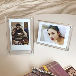 Macro detail of two transparent acrylic photo frames with magnetic metal corner fixings
