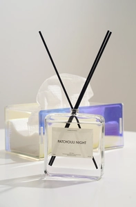 Close-up of reed diffuser set with holographic acrylic tissue box in home setting