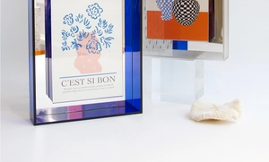 Close-up of blue acrylic art frame with floral illustration and C'EST SI BON text