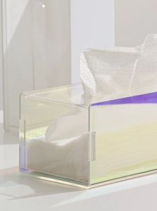 Macro view of iridescent acrylic tissue box surface showing gradient rainbow colors