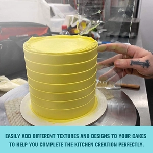 Close-up of acrylic cake scraper creating uniform textured lines on cream frosting
