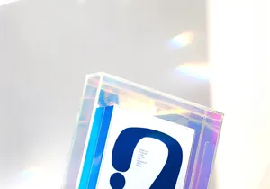 Close-up of iridescent acrylic photo frame showing colorful light effects and art card