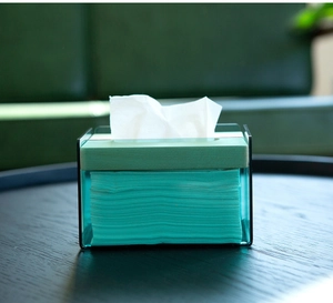 Close-up of translucent blue acrylic tissue box with a wooden lid on a black desk
