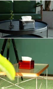 Detail of rectangular acrylic tissue boxes in smoky gray and amber red finishes