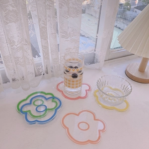 Gros plan de sous-verres en acrylique en forme de fleurs dans un décor ensoleillé