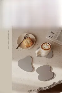 Detail of irregular acrylic mirror coasters on a stone surface for Nordic table decor