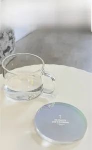 Macro shot of an 8mm rainbow acrylic coaster with religious text and a glass cup