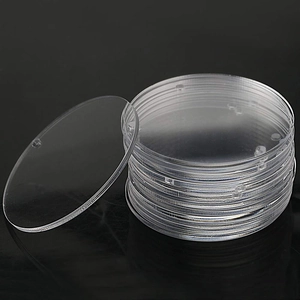 Stack of clear round acrylic discs for DIY painting on a black reflective background