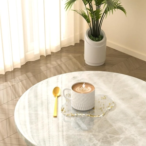 Close-up of irregular petal acrylic coaster with gold foil on marble table