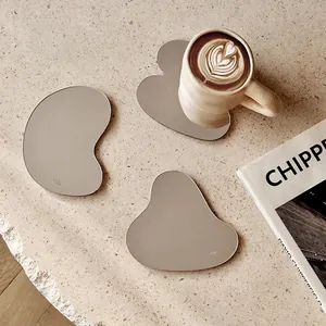 Set of 3 irregular acrylic mirror coasters in Nordic style on a beige stone desk