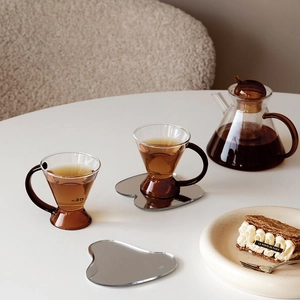 Nordic amber glass tea set with teapot and irregular acrylic mirror coasters on marble