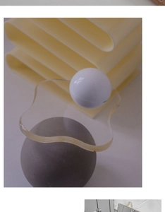 Detail view of a clear acrylic wavy tray balanced on artistic geometric decor shapes