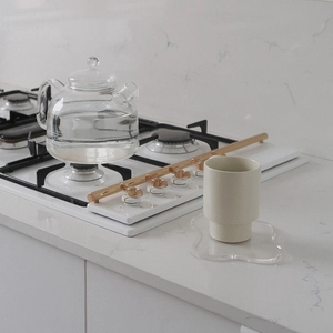 Minimalist ceramic cup on wavy acrylic coaster with gold accent kitchenware details