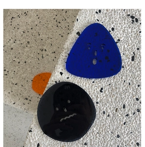 Close-up of translucent Klein blue acrylic coasters with minimalist facial expressions