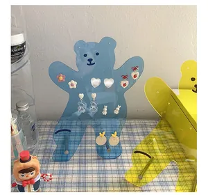 Macro detail of bear-shaped acrylic earring holder with blue and yellow finish