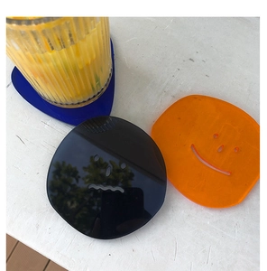 Close-up of colorful acrylic coasters with emoji faces and blue glass tray set