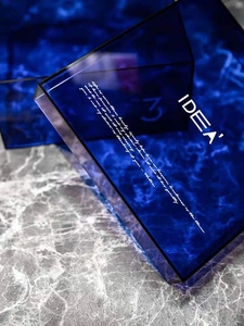 Detailed view of deep blue acrylic organizer tray with white IDEA engraving and artistic text
