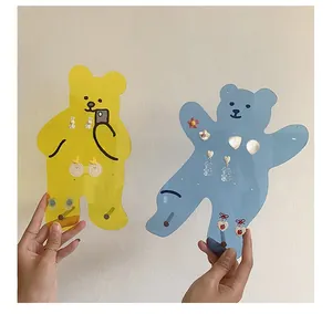 Detail of bear-shaped acrylic earring organizer with multiple holes in yellow and blue
