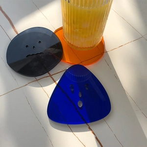 Klein blue acrylic coasters with fun cut-out expressions in irregular shapes on white desk