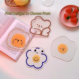 Cartoon acrylic coasters with bear, cloud, and egg designs on a white tabletop