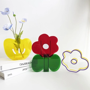 Close-up of geometric acrylic vases in yellow heart, red petal, and abstract wave shapes