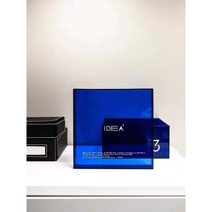 Modern translucent blue acrylic storage box with white minimalist lettering on a white desk