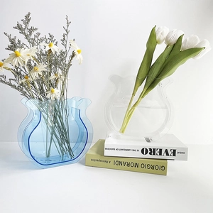 Macro shot of stylish blue and clear acrylic vases with unique wavy edge design