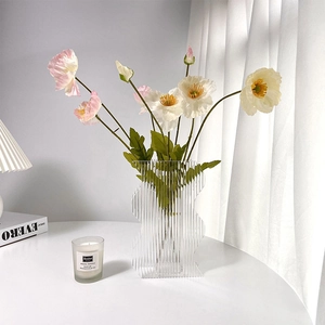 Detail of wavy colorful acrylic vase with vertical stripes and faux poppy flowers