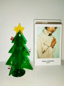 Detail view of mini acrylic Christmas tree with green branches and yellow star topper