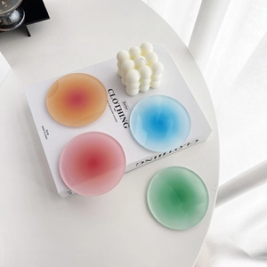 Set of four round gradient acrylic coasters in vibrant sunset colors with matte finish