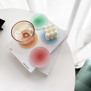 Close-up of translucent frosted acrylic coasters in gradient colors on aesthetic books