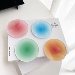 Close-up of four colorful gradient acrylic coasters in pink, blue, green and orange