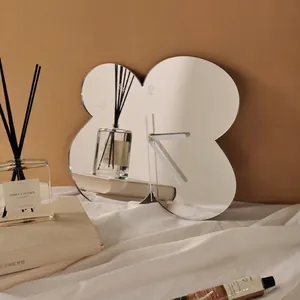 Minimalist petal-shaped mirror wall clock with laser engraved numbers on warm wall