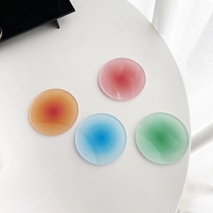Detail view of round acrylic coasters with gradient sunset colors and translucent finish